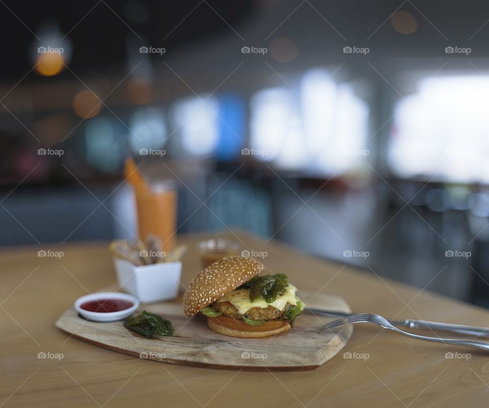 Cheese Burger on a wooden board at a bar restaurant. Selective focus with blurred background