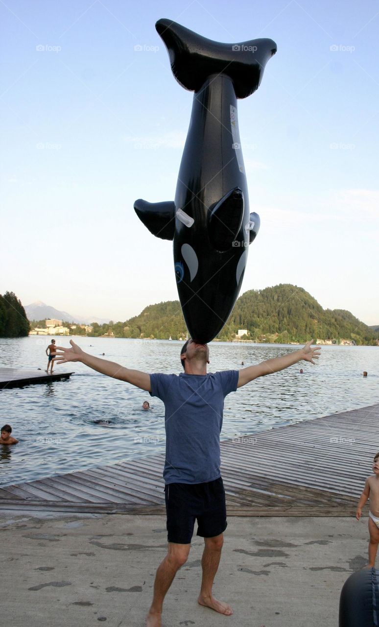 Man balance inflated whale on his nose