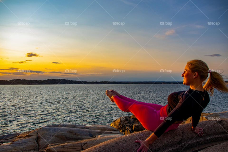 a yoga woman ,sunrise at the rocks at the sea . Its a beautiful day ,go out anf grab it