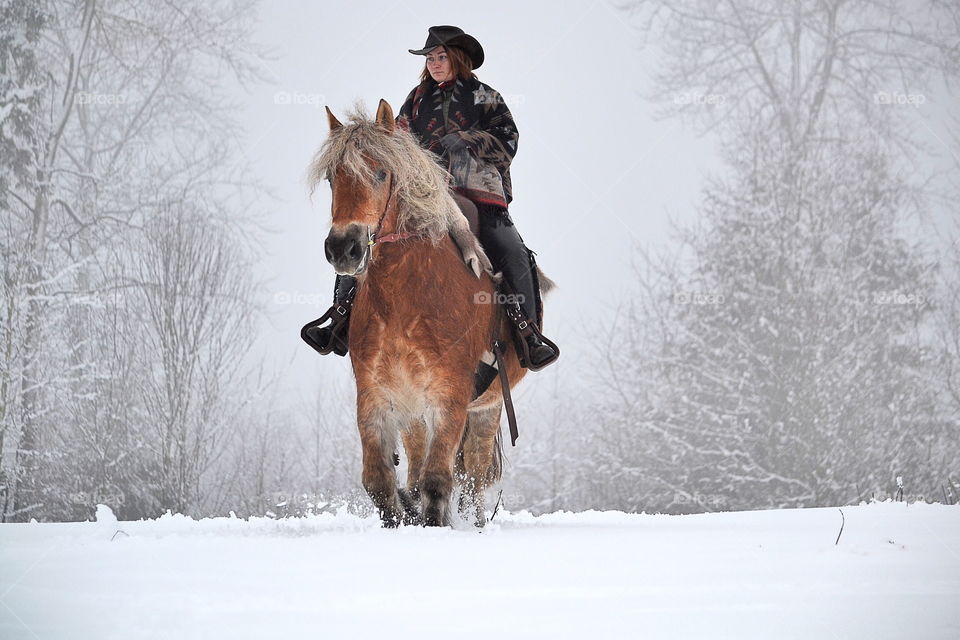 Woman horseback riding in winter