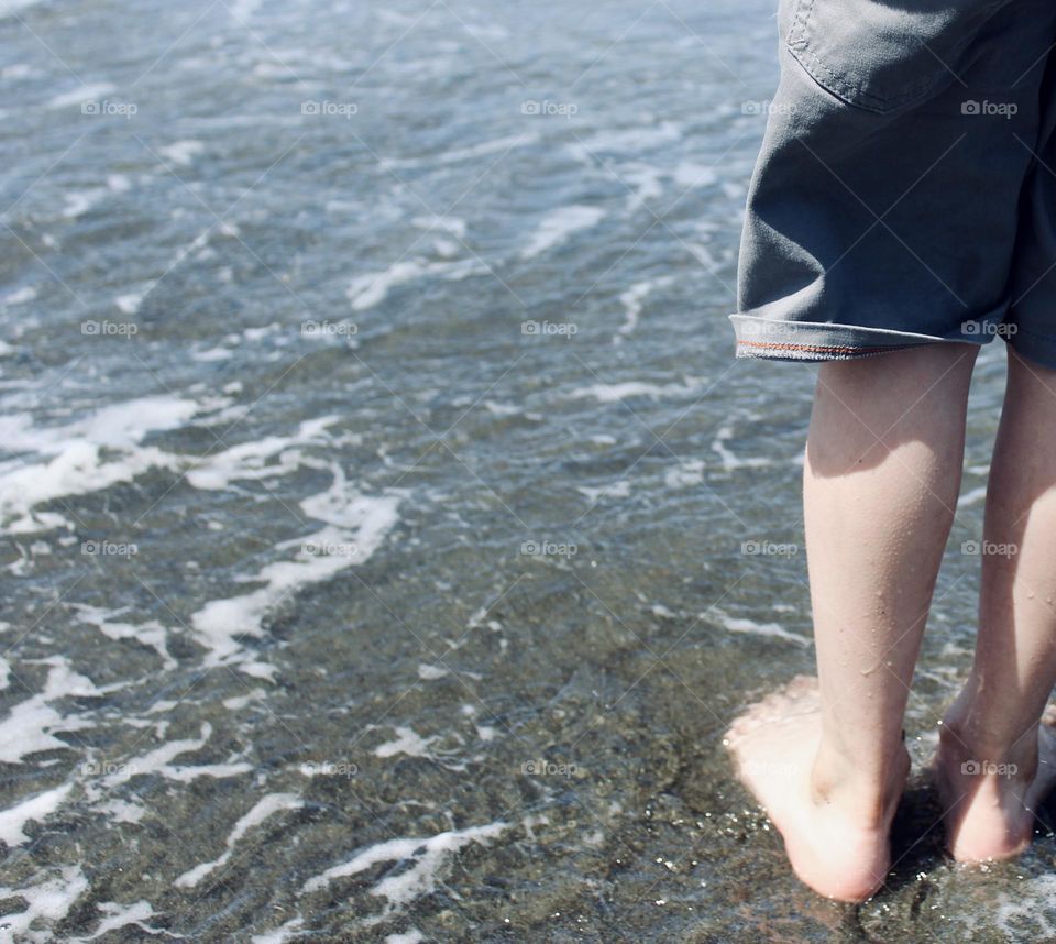 Young boys feet in the ocean water 