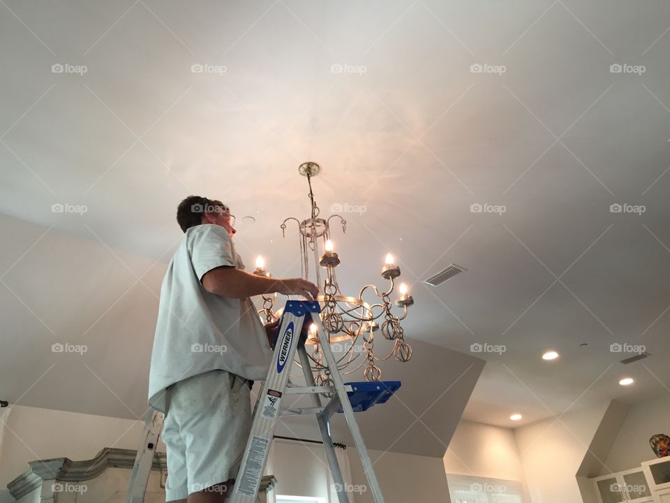 Man hanging a chandelier