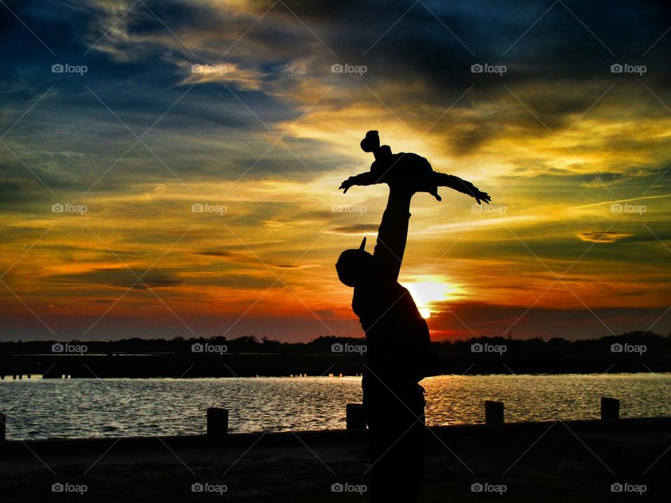 Silhouette of father carrying his daughter