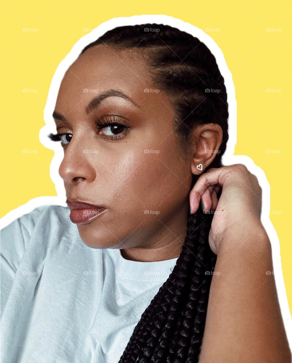 African American woman with makeup on. A moody picture. Outlined with white with a canary yellow background.