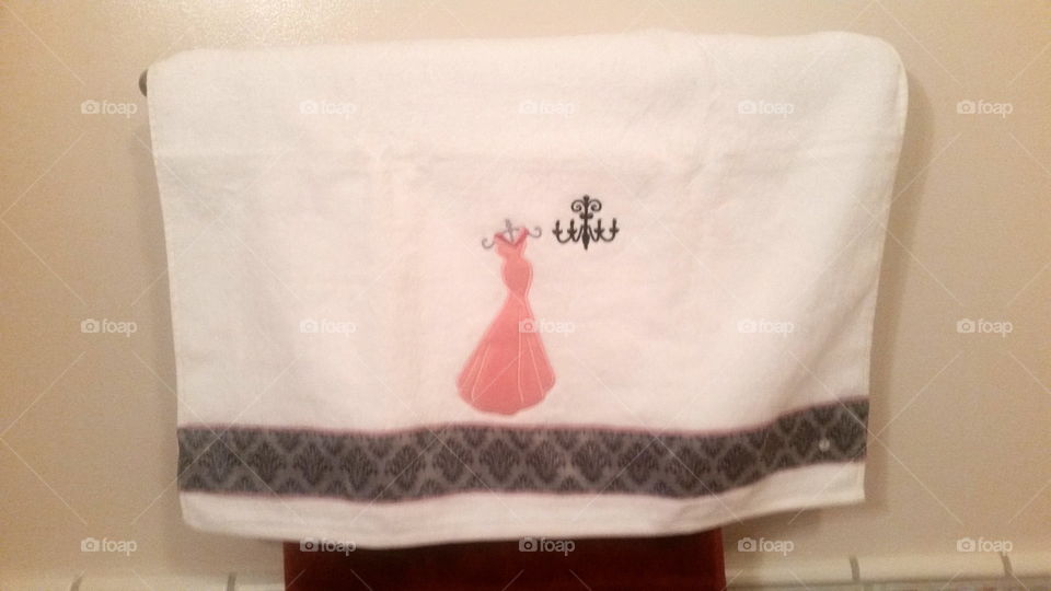 White towel with a pink dress and chandelier design on it.