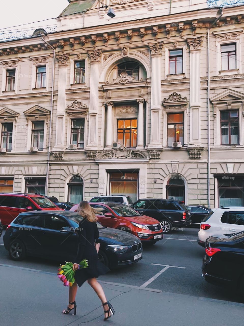 A lady with flowers walking down the street