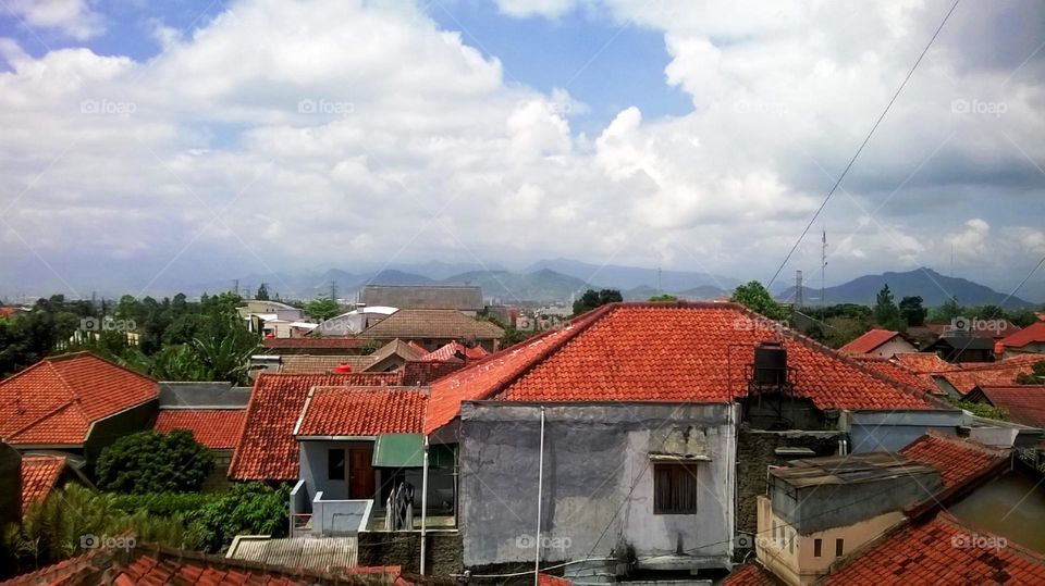 View of residential areas against the background of mountains and panoramic clouds.