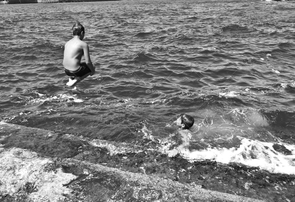 Two children floating in the sea,black and white