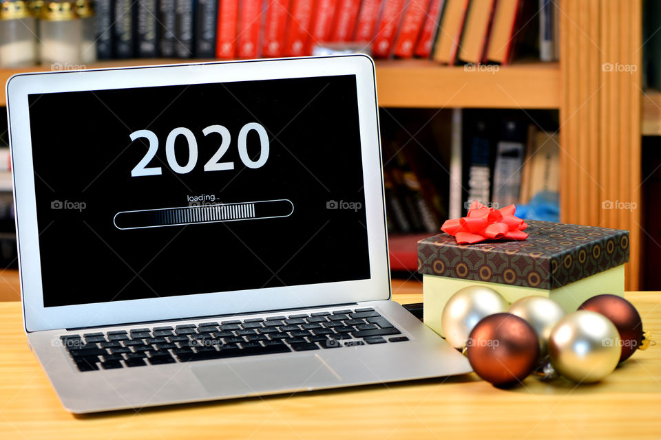 Text - 2020 loading and loading bar on laptop desktop, bookshelf, christmas ball, new year concept
