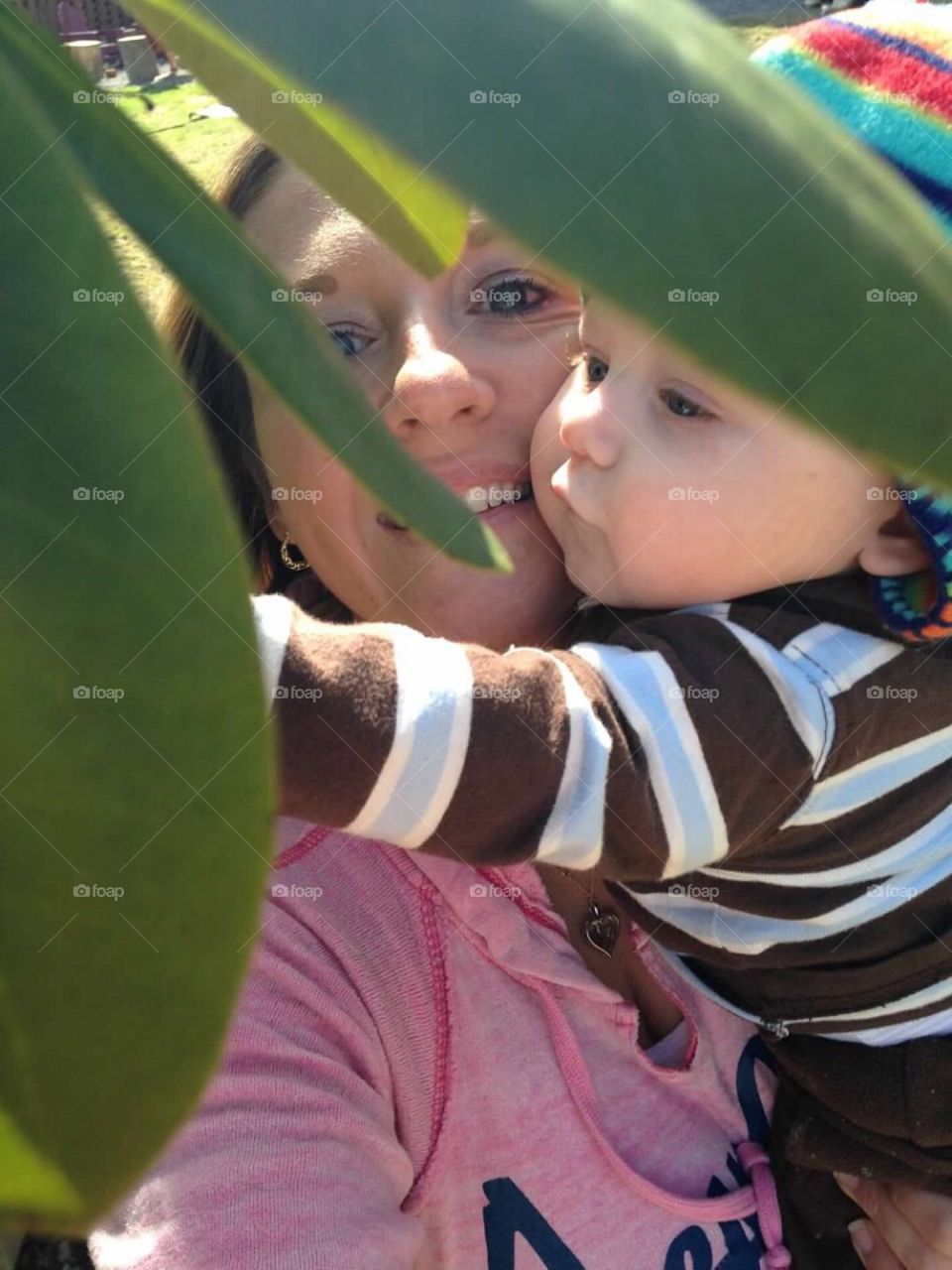 Mother and son behind plant