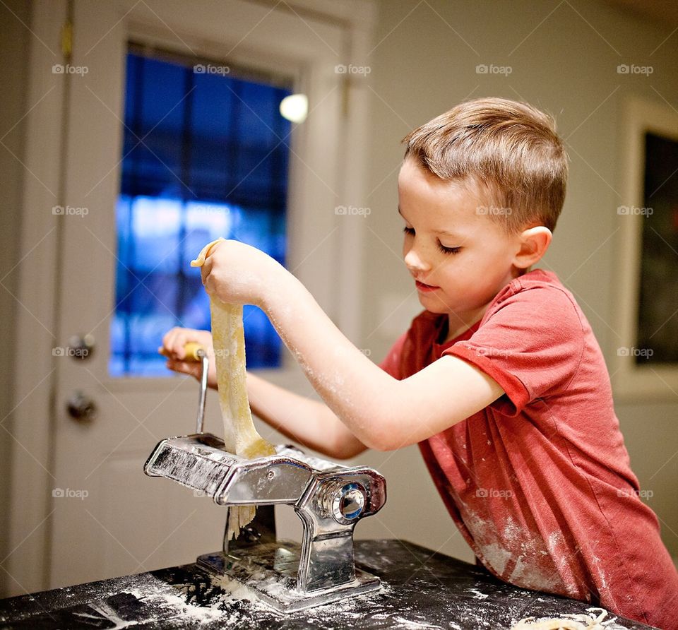 Boy cooking pasta in the kitchen