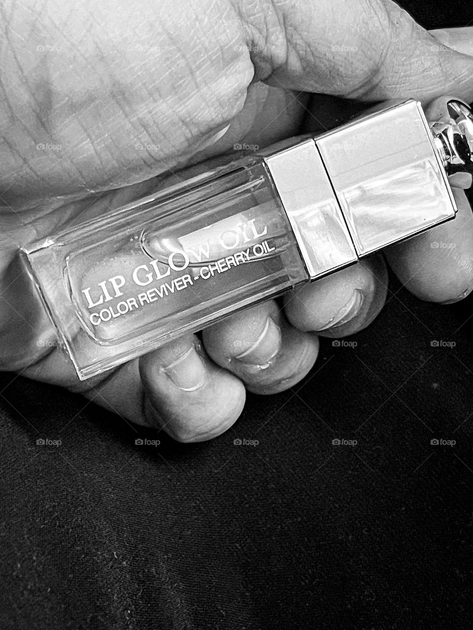 Holding a lipgloss in black and white mode