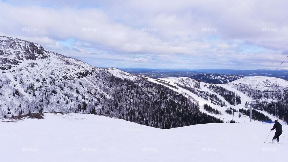 Man skiing against snowcapped mountains