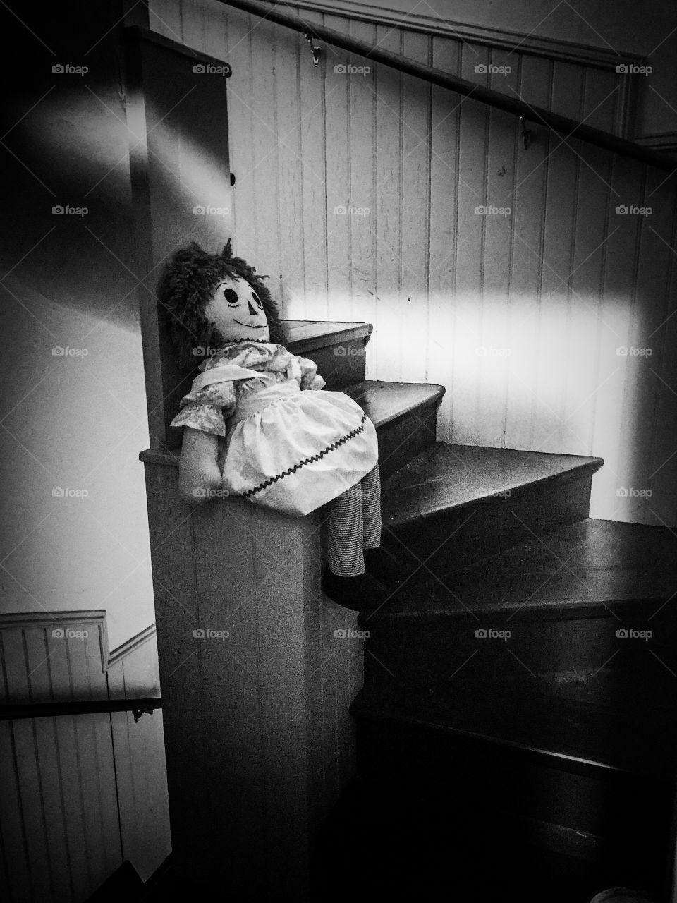 Creepy raggedy Ann doll in stairway