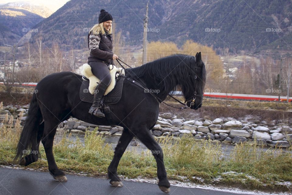 Side View Of Happy Woman Riding A Friesian Horse In Naters,Wallis