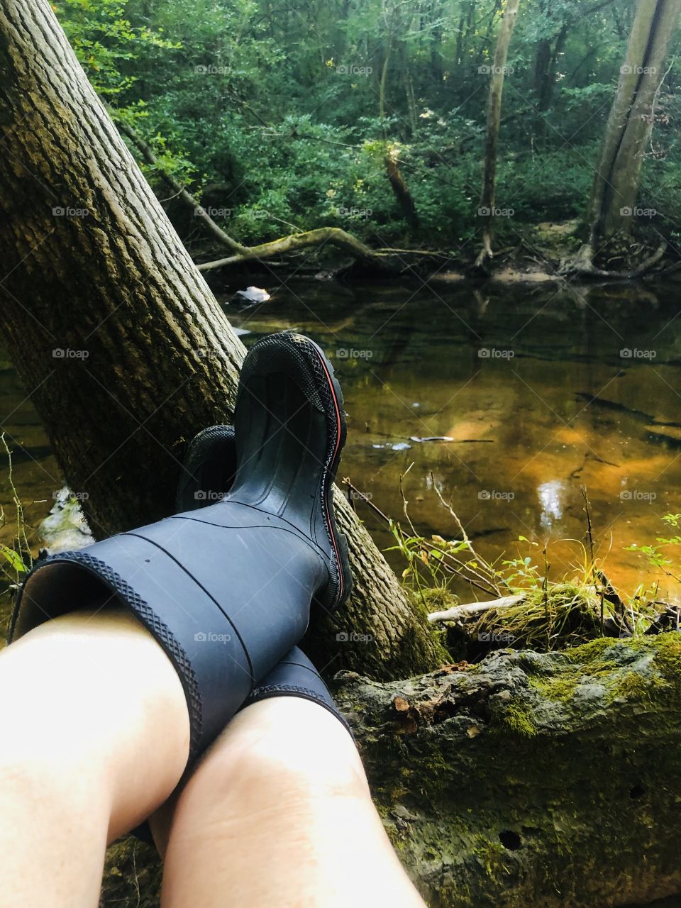 Relaxing feet up by cool mountain stream during summer heat