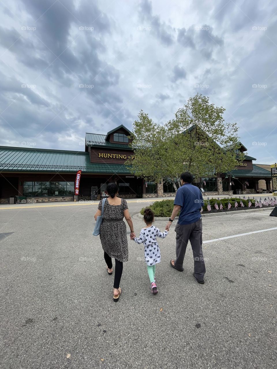 Grandparents walk with grandchild into retail store, walking into Cabelas with Grandma and Grandpa, grandparents take child shopping 