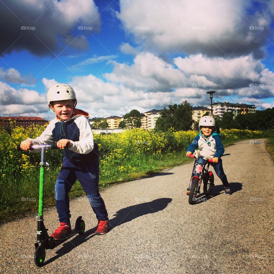 Brothers on kick bike and bike at Gärdet, Stockholm