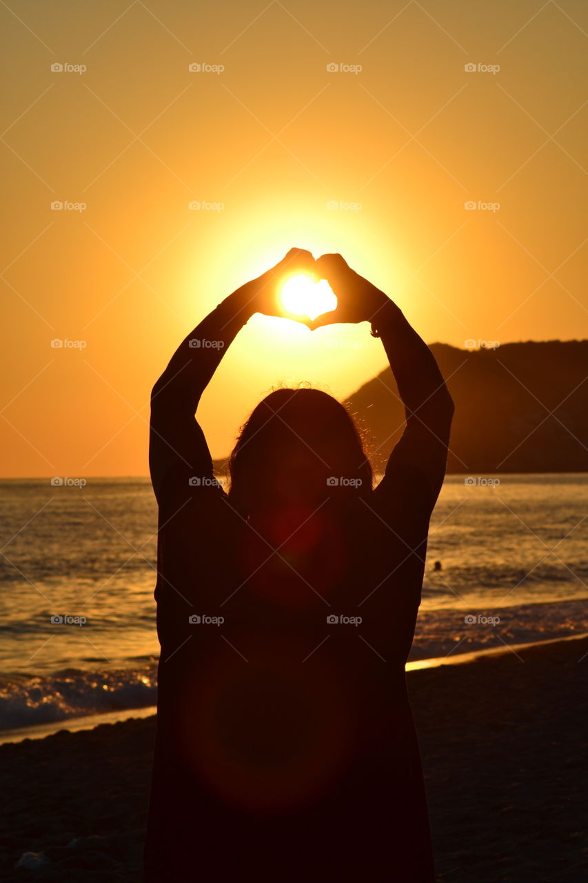 woman forming hands in shape of a heart.