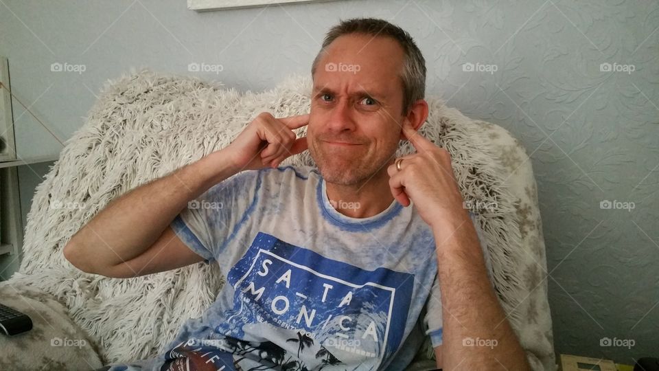 man not listening,  fingers in the ears