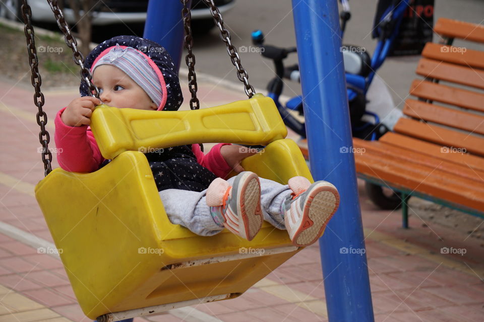 A child riding on a swing