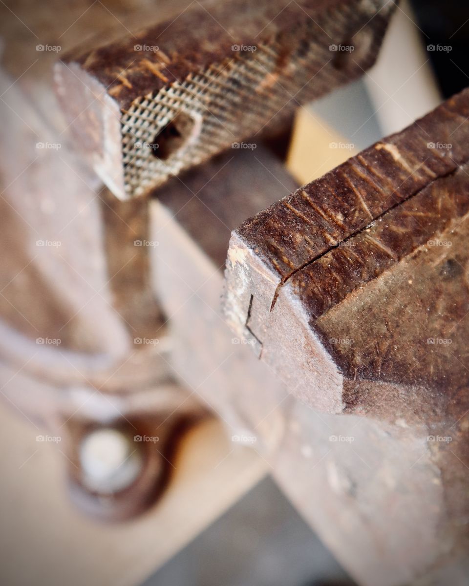 A rusty vintage swivel vise with anvil displays many years of use 