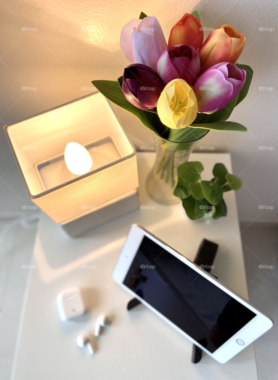 My bedside favorites. iPad, AirPods, Mini lap, tulips and a mini plant. Chill zone. 
