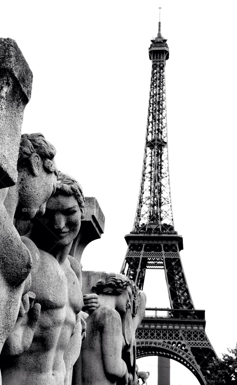 Statues of lovers under the shadow of the Eiffel Tower in Paris,