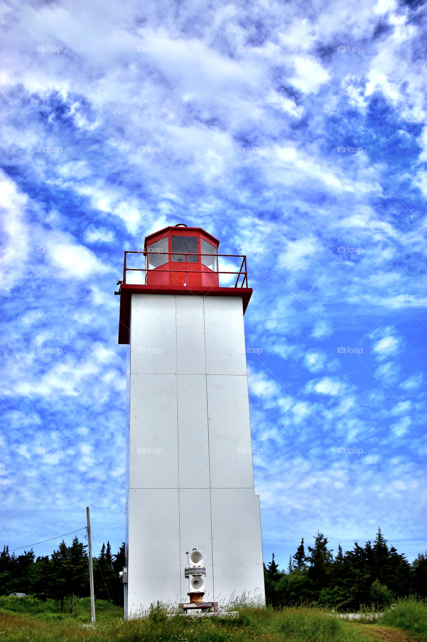 New Brunswick Canada lighthouse on a road trip in the summer with a beautiful sky 