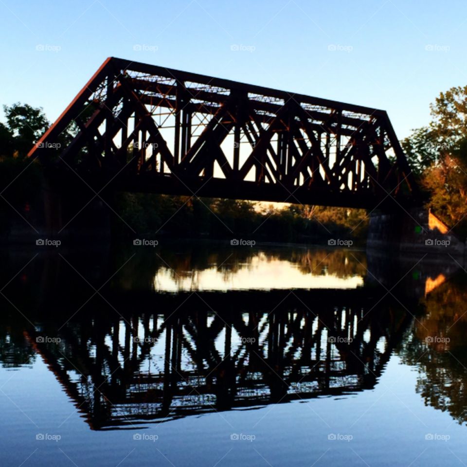 Reflection of a railroad bridge over the river 