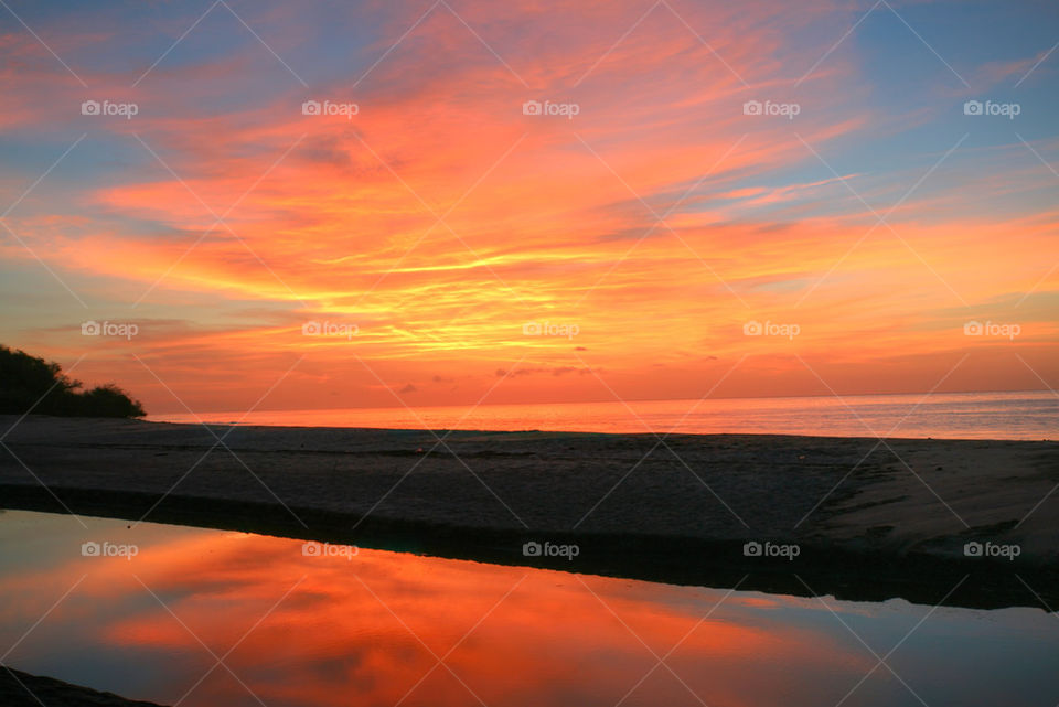 sunrise over the pacific ocean and the end of the lake with reflection