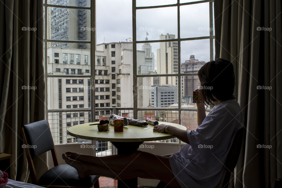 Woman drinking coffee by the window