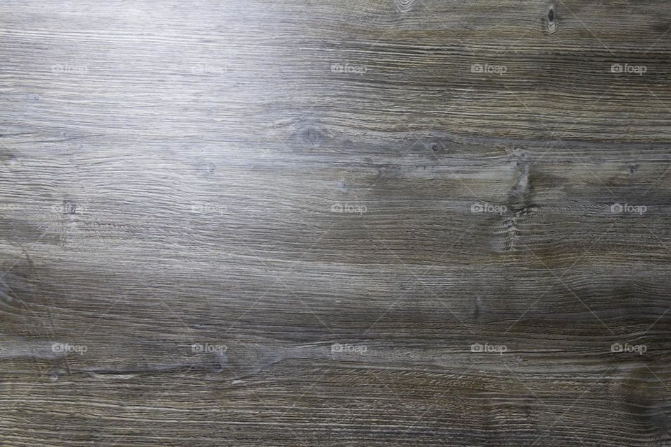 A gray wooden surface that is used as a background with a light feeding from the left side.