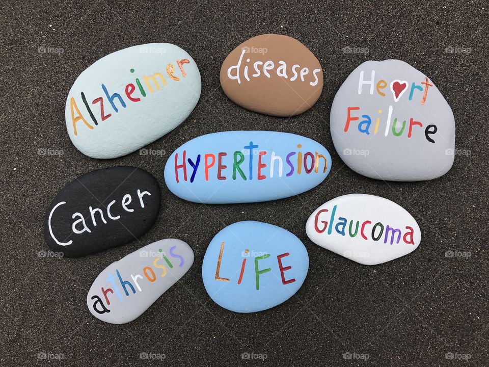 Cloud of diseases painted on stones over black volcanic sand