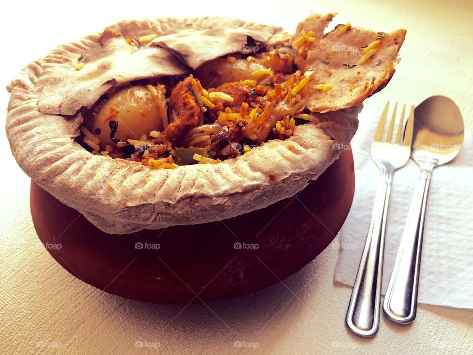 My authentic style homemade chicken Biryani ( indian spicy rice ) in a clay pot, covered with dough on top and was left for slow cooking..