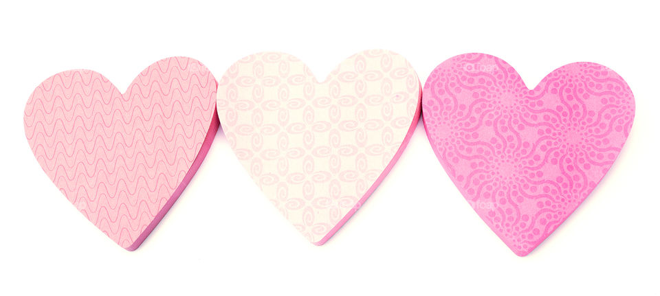 Three pink heart shaped notepads isolated on white.