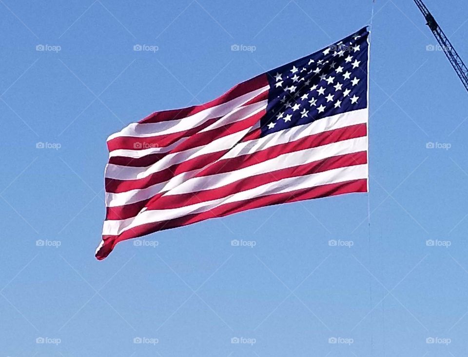 The United States flag, proudly waving in the cloudless, blue Texas sky.