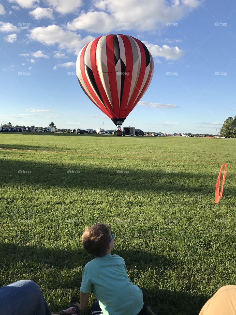 Child watching hot air balloon take off 
