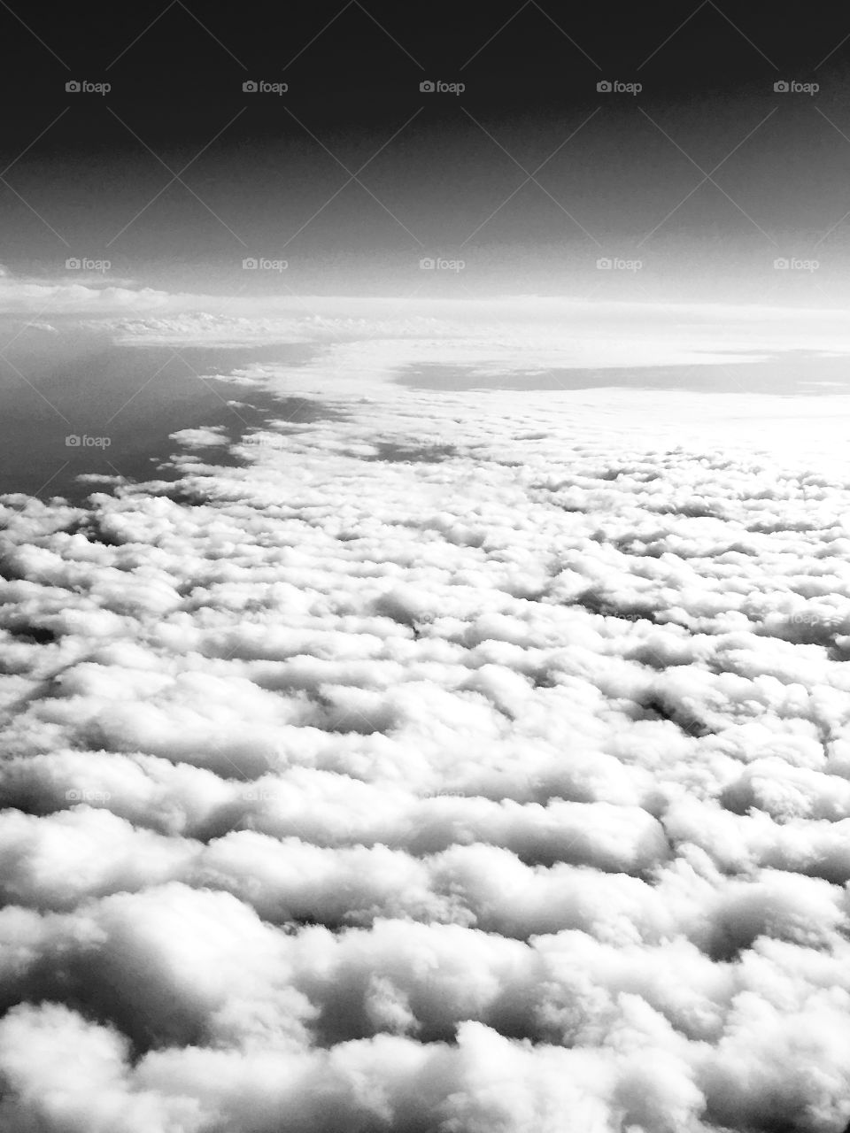 Looking down on clouds from above, in black and white.
