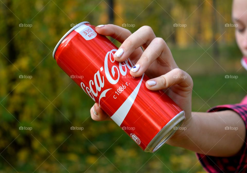 coca cola in female hand, drinking coca cola outdoor