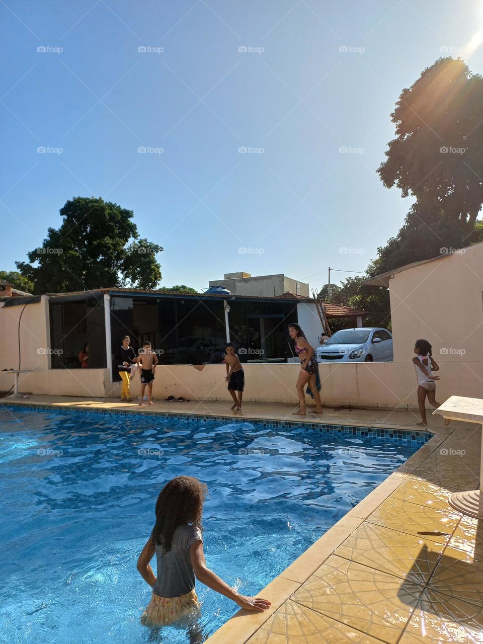From the Group Crianças brincando na piscina num tarde de Céu azul