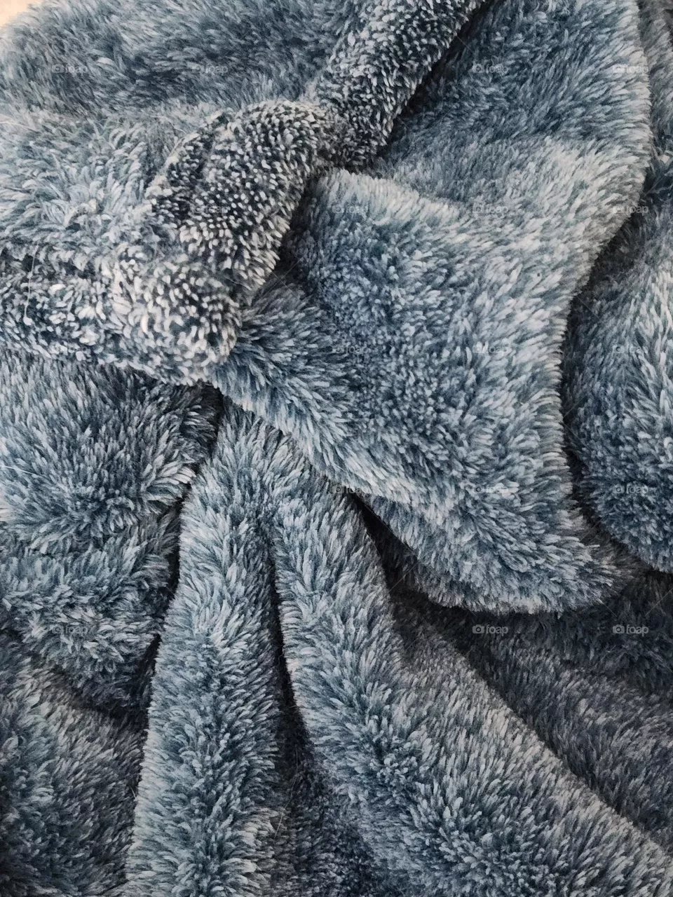 close up of a cozy blue gray plush comfort blanket to curl up in at home