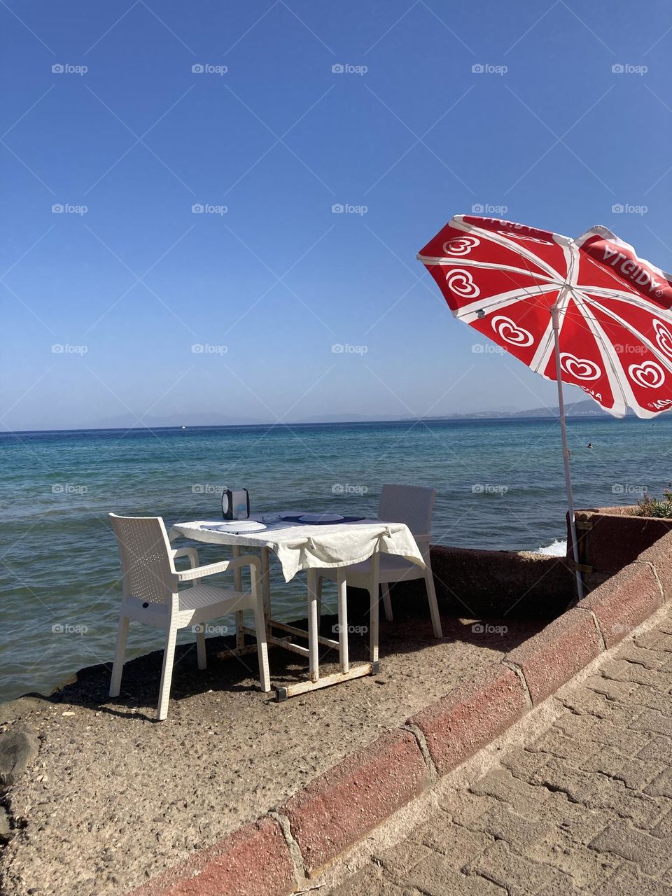 Sunny holidays I’m Turkey. Walk in the cute city and charming streets by the beach in Kusadasi. perfect blue sky and ocean view. Beach and the shore. To travel is to live. Gorgeous tall palm trees.
