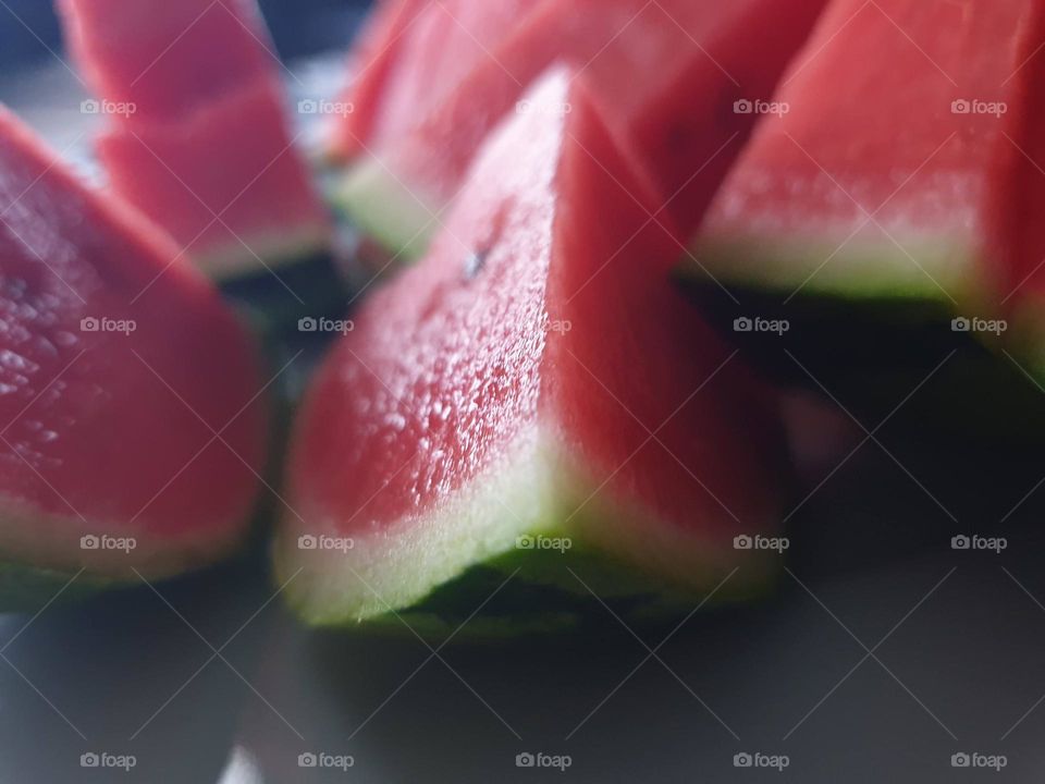 a close up portrait of slices of watermelon. the healthy fruit is ready to be eaten.