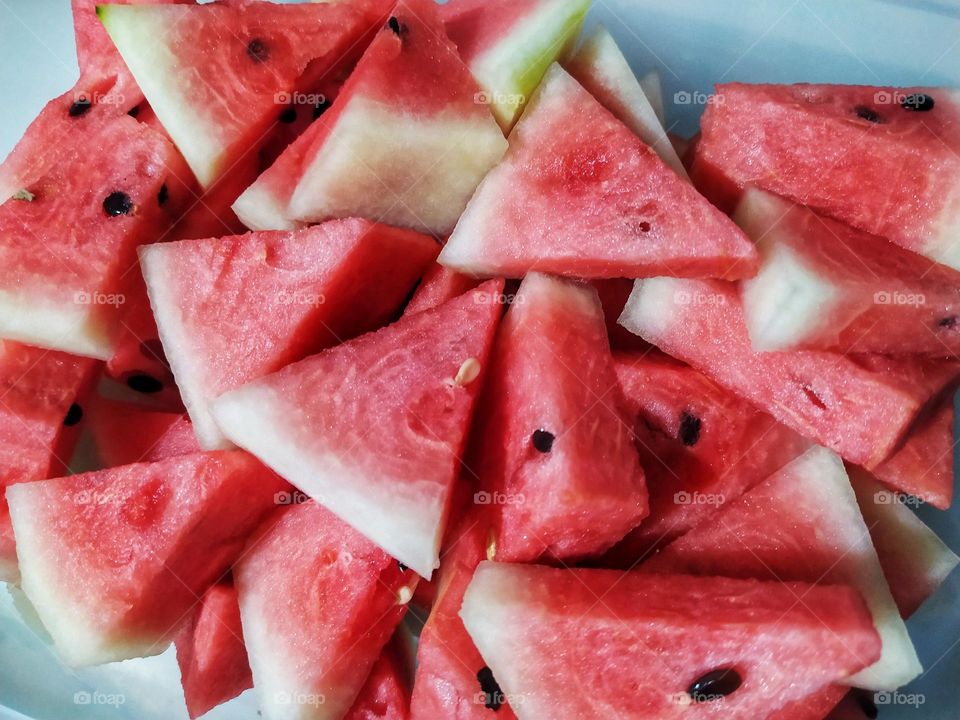 Pile of watermelon pieces in a triangular shape ready to eat