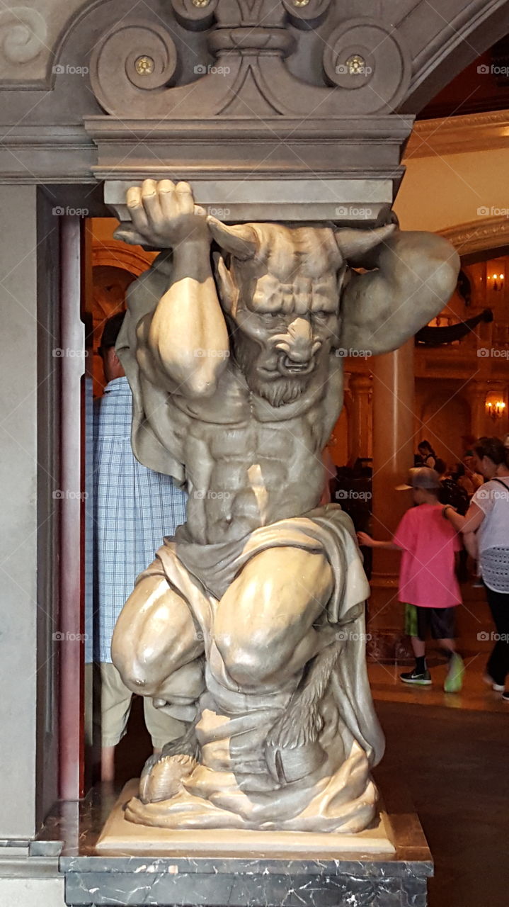 Gargoyle holding up arch at Be Our Guest restaurant