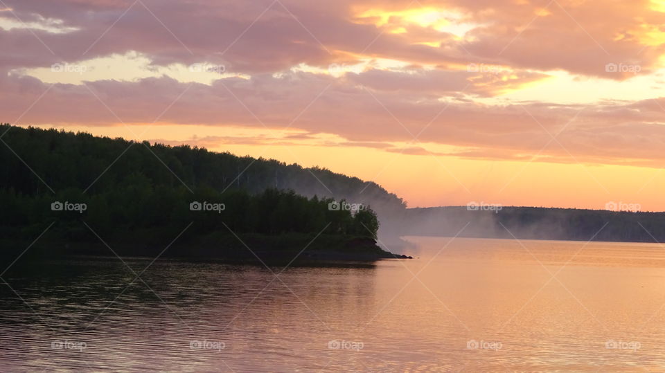 steam above the lake after the rain at sunset of the day