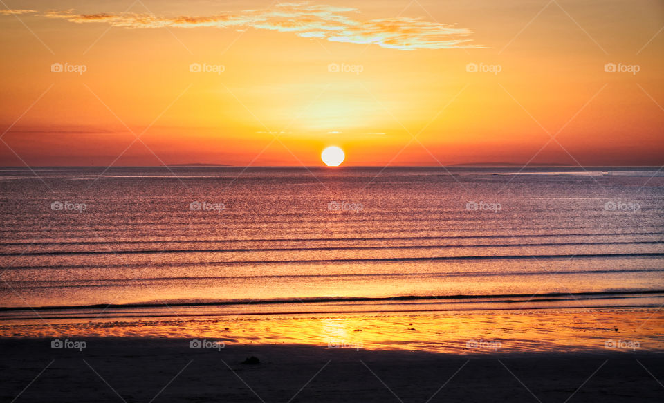 Sunset touching the ocean at Silverstrand beach, Galway, Ireland