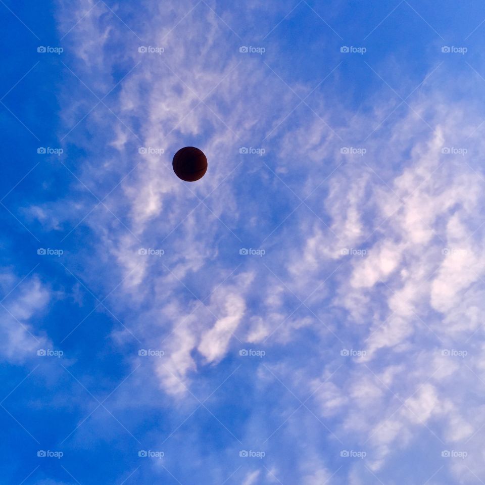 Basketball thrown up into the colourful sky. Somehow managed to throw the ball and take the picture!