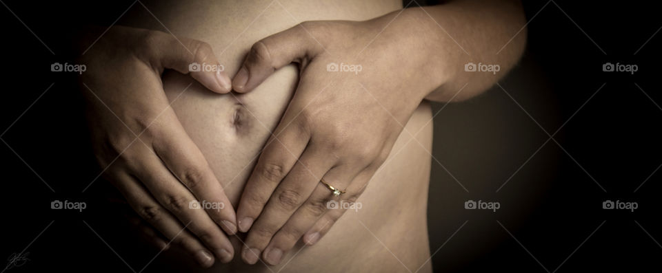 Pregnant woman forming a heart with her hands on her belly